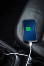 Mobile phone ,smartphone, cellphone is charged ,charge battery with usb charger in the inside of car. modern black car interior Royalty Free Stock Photo