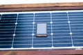 Mobile phone on a solar panel outdoor close up