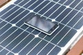 Mobile phone on a solar panel outdoor close up