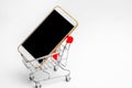 Mobile phone in a supermarket trolley. buying and selling a smartphone. online store. consumer credit. isolated white background