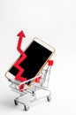 Mobile phone in a supermarket trolley and a red arrow up. high demand for the purchase of a smartphone. online store. consumer cre Royalty Free Stock Photo