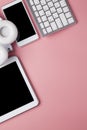 Mobile phone, tablet, computer keyboard, headphones and notebook on pink background