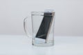 Mobile phone in vessel with water. Royalty Free Stock Photo