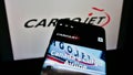 Mobile phone with web page of Canadian cargo airline Cargojet Inc. on screen in front of company logo.