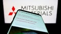 Mobile phone with webpage of company Mitsubishi Materials Corporation (MMC) on screen in front of logo. Royalty Free Stock Photo