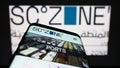 Mobile phone with webpage of Egyptian Suez Canal Economic Zone (SCZONE) on screen in front of logo.