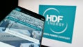 Mobile phone with webpage of French hydrogen company HDF Energy on screen in front of business logo.