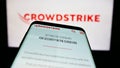 Mobile phone with website of cybersecurity company CrowdStrike Holdings Inc. on screen in front of logo. Royalty Free Stock Photo