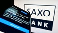 Mobile phone with website of Danish investment banking company Saxo Bank AS on screen in front of logo. Royalty Free Stock Photo