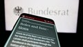 Mobile phone with website of German legislative body Bundesrat on screen in front of seal.