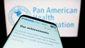 Mobile phone with website of Pan American Health Organization (PAHO) on screen in front of logo. Royalty Free Stock Photo