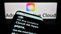 Mobile phone with website of software Adobe Creative Cloud on screen in front of company logo.