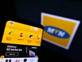 Mobile phone with website of South African telecommunications company MTN Group on screen in front of logo.