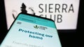 Mobile phone with website of US environmental organization Sierra Club on screen in front of logo.