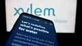 Mobile phone with website of US water technology company Xylem Inc. on screen in front of business logo.