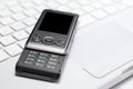 Mobile phone on white laptop keyboard Royalty Free Stock Photo