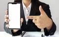 Mobile phone with a white screen for putting text and pictures in the hands of business women. Royalty Free Stock Photo