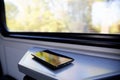 Mobile phone on window seat in a modern comfortable train Royalty Free Stock Photo