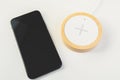 Mobile phone and wireless charger on office table Royalty Free Stock Photo