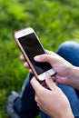 Mobile phone in woman's hand in a deckchair against the background of the river. Telephone, Deckchair, green grass, river. Time t Royalty Free Stock Photo