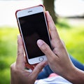 Mobile phone in woman's hand in a deckchair against the background of the river. Telephone, Deckchair, green grass, river. Time t Royalty Free Stock Photo