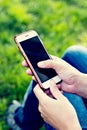 Mobile phone in woman's hand in a deckchair against the background of the river. Telephone, Deckchair, green grass, river. Time t Royalty Free Stock Photo