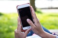 Mobile phone in woman's hand in a deckchair against the background of the river. Telephone, Deckchair, green grass, river. Time t Royalty Free Stock Photo