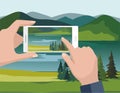 Mobile photography concept. Man taking photos of nature landscape with fir trees and river to phone.