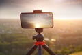 Mobile photography with smartphone on tripod shooting landscape with sunset