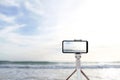 Mobile photography and video on a journey. Smartphone on a tripod on the background of the sea in Spain in Palma de