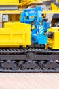 A blue hydraulic crane on a yellow crawler mobile construction platform
