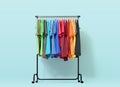 Mobile rack with color clothes on light blue background. File contains a path to isolation. Royalty Free Stock Photo