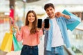 Happy Buyers Couple Showing Cellphones Advertising App Shopping In Mall