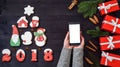 Mobile smart phone with blank screen for app presentation in woman hands, copy space. Christmas background. Christmas gifts. Royalty Free Stock Photo