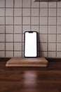 Mobile smart phone on kitchen counter with blank white mockup screen for cooking app or internet page display Royalty Free Stock Photo