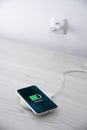 Mobile smart phone on wireless charging device on white background. Icon battery and charging progress lighting on screen. Royalty Free Stock Photo