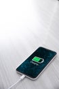 Mobile smart phone on wireless charging device on white background. Icon battery and charging progress lighting on screen. Royalty Free Stock Photo