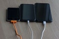 Mobile smart phones charging on wooden table