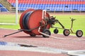 Mobile sprinkler on an empty green soccer field. Big drum with a hose for watering a football field Royalty Free Stock Photo