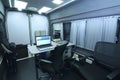 Mobile state administrative services office set in the interior of mini bus: laptops, monitors, phones, printer and