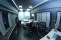 Mobile state administrative services office set in the interior of mini bus: laptops, monitors, phones, printer and