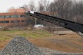 Mobile stone crusher machine by the construction site or mining quarry for crushing old concrete slabs into gravel belt