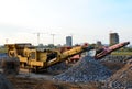 Mobile Stone crusher machine by the construction site or mining quarry for crushing old concrete slabs into gravel and subsequent Royalty Free Stock Photo