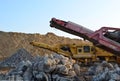 Mobile Stone crusher machine by the construction site or mining quarry for crushing old concrete slabs into gravel and subsequent Royalty Free Stock Photo