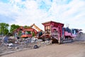 Mobile Stone Jaw crusher machine and excavator during crushing concrete on construction site. Salvaging and recycling of the