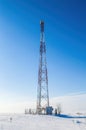 Mobile tower in a snow-covered white field against a blue sky Royalty Free Stock Photo