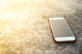 Moblie smart phone on stone table sun light background. Royalty Free Stock Photo