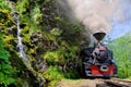 Mocanita Steam Train and the narrow gauge through green mountains with blue sky