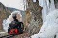 Mocanita Steam Train passing on the forestry railway with Cold winter ice