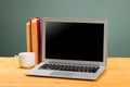 Laptop with blank screen, cup of coffee and books or notebooks on a wooden table. mockup for your text Royalty Free Stock Photo